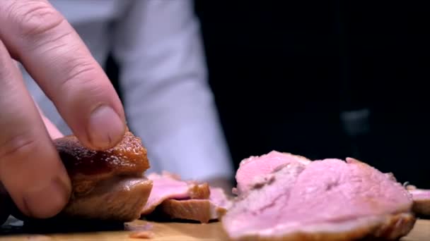 Cutting duck breasts with a knife on a wooden board — Stock Video