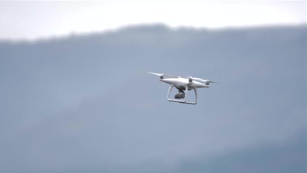 Drohne fliegt in Silhouette vor blauem Himmel, Drohne auf blauem Hintergrund im Sonnenlicht, Zeitlupenaufnahme — Stockvideo