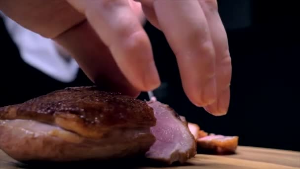 Cutting duck breasts with a knife on a wooden board — Stock Video