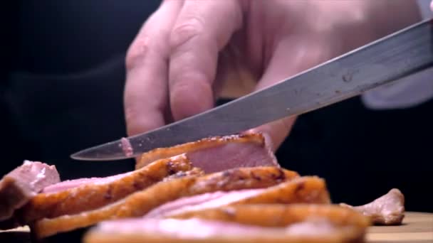 Резание утиной груди ножом на деревянной доске — стоковое видео