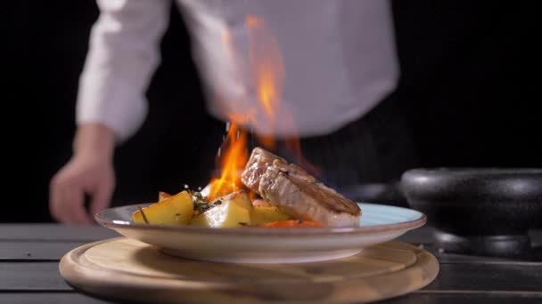 Close-up de um Chef Preparando prato estilo Flambe em uma panela. Óleo e Álcool Ignite com Chamas Abertas. Tiro na câmera de cinema de hélio vermelho EPIC-W 8K . — Vídeo de Stock