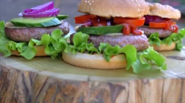 Yavaş hareket eden yiyecek konsepti. Şef hamburger yapıyor. Yakın plan. Burger restoranının menü pişirme işlemi. Şef restoranda fast food hazırlıyor. Siyah ekmeğe peynir sosu döküyor..