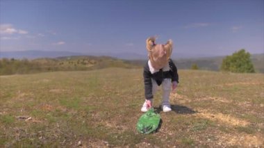 Küçük kız yeşil bir ormanda dilek dolu bir kavanoz tutuyor.