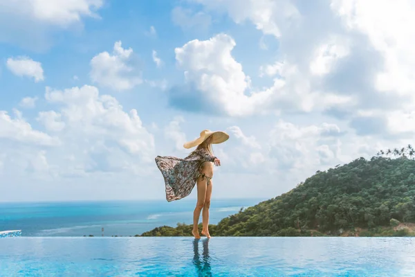 一个穿着泳衣 头戴帽子 身穿长袍的漂亮姑娘站在一座别墅里 那里有游泳池 还有丛林和大海的美丽景色 泰国Samui — 图库照片