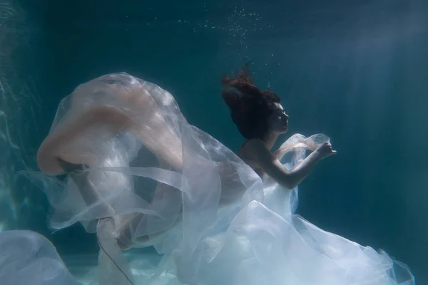 Menina Bonita Nada Debaixo Água Com Cabelos Longos Fundo Azul — Fotografia de Stock