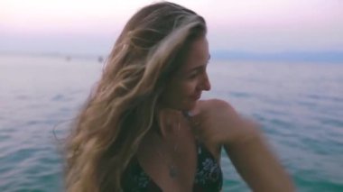 Güzel, ince ve genç bir kız turkuaz denizde yüzüyor. Uzun saç ve modelde ince bir figür. Bir kadın suya dalıyor ve su sıçrıyor. Sakinlik, mutluluk ve rahatlama kavramı..