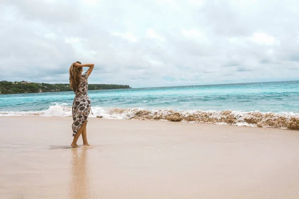 青い波で海と海の海岸にポーズをドレスで美しく 若い女の子 ロングドレスモデルやファッションポージングの女性 バリ島でリラックスしてリラックスしてください — ストック写真