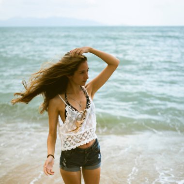 Güzel erkek ve kız koşar ve okyanusta veya denizde sahilde eğlenirler. Karı kocanın tropiklerinde balayı. Ateşli ülkelerde aşk. Kumda yuvarlan ve mutlu ve aşık ol. Aşıklar