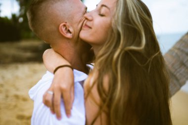 Güzel erkek ve kız koşar ve okyanusta veya denizde sahilde eğlenirler. Karı kocanın tropiklerinde balayı. Ateşli ülkelerde aşk. Kumda yuvarlan ve mutlu ve aşık ol. Aşıklar