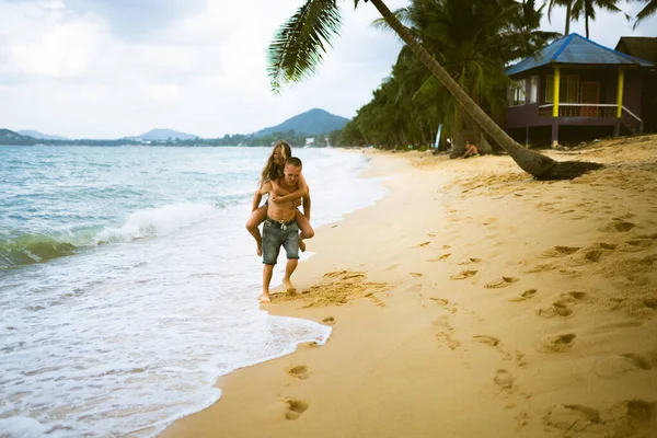 美丽的男人和女孩在海滩上跑着 享受着大海的乐趣 蜜月在热带的丈夫和妻子 在炎热的国家浪漫 沉溺在沙子里 快乐地恋爱吧 — 图库照片