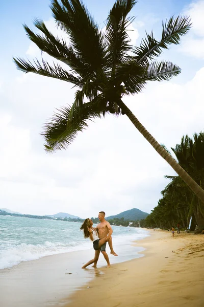 美しい男と女の子が走り 海や海のビーチでお楽しみください 夫と妻の熱帯の新婚旅行 熱い国のロマンス 砂の中に飲み込み 幸せになると愛にあります 恋人たち — ストック写真