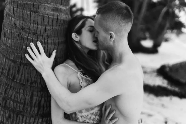 Beautiful guy and girl run and enjoy on the beach on the ocean or sea. Honeymoon in the tropics of a husband and wife. Romance in hot countries. Wallow in the sand and be happy and in love. Lovers