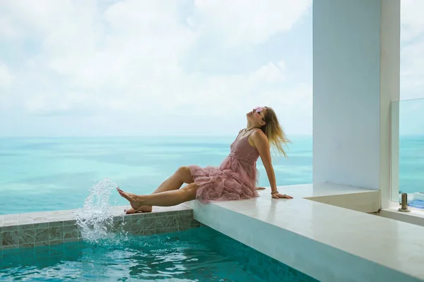 一个美丽的女人正在一座富丽堂皇的别墅里休息 那里有一个游泳池 可以欣赏大海和棕榈树的美丽景色 脸的画像 假期愉快有女孩的异国情调和热带地区 — 图库照片