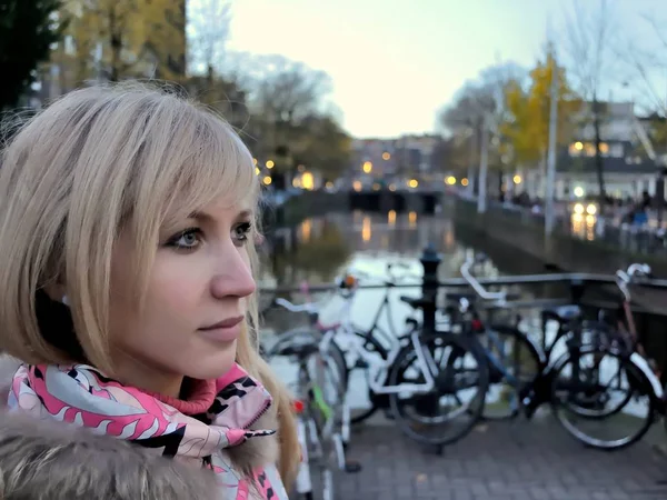 Avrupa kız pembe ceket ve Amsterdam kanal mavi saat (akşam) Bisiklet arasında yakınındaki pembe çizme