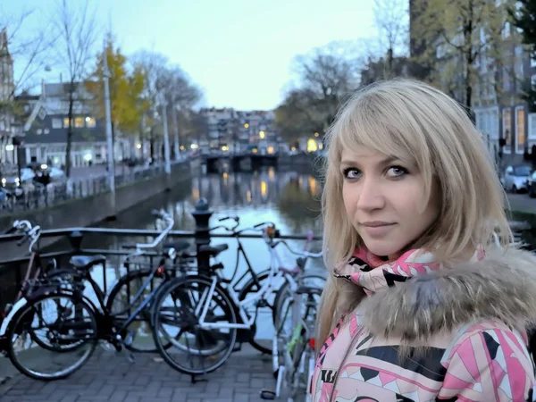 Avrupa kız mavi saat (akşam) Bisiklet arasında Amsterdam kanal yakınındaki pembe ceket