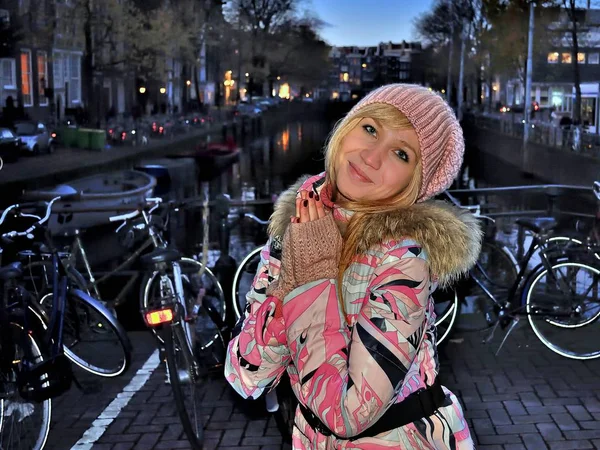 Amsterdam kanal mavi saat (akşam) Bisiklet arasında yakınındaki pembe ceket Avrupa gülümseyen kız