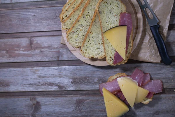 Ahşap arka planda et, peynir ve ekmek
