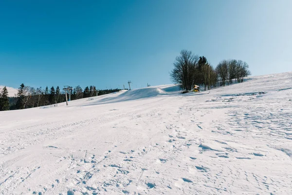 Pista de esquí en invierno. Hermoso cielo azul, mucha nieve, sin gente — Foto de Stock