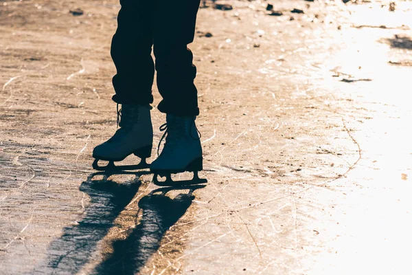 Una joven de pie en patines en un estanque congelado en ic —  Fotos de Stock