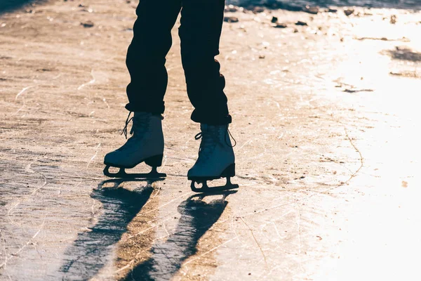 Una joven de pie en patines en un estanque congelado en ic — Foto de Stock
