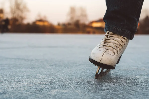 Uma jovem de pé em patins em uma lagoa congelada no gelo — Fotografia de Stock