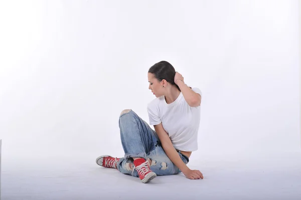 Joven posando en pantalón azul jean y thsirt blanco en el estudio — Foto de Stock