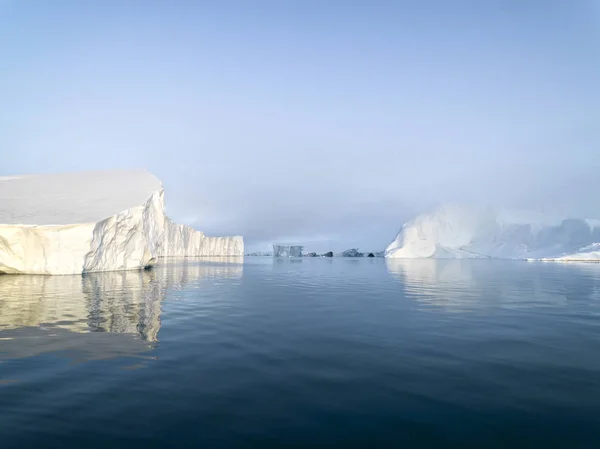 Arctic Icebergs Greenland in the arctic sea. You can easily see that iceberg is over the water surface, and below the water surface. Sometimes unbelievable that 90% of an iceberg is under water — Stock Photo, Image