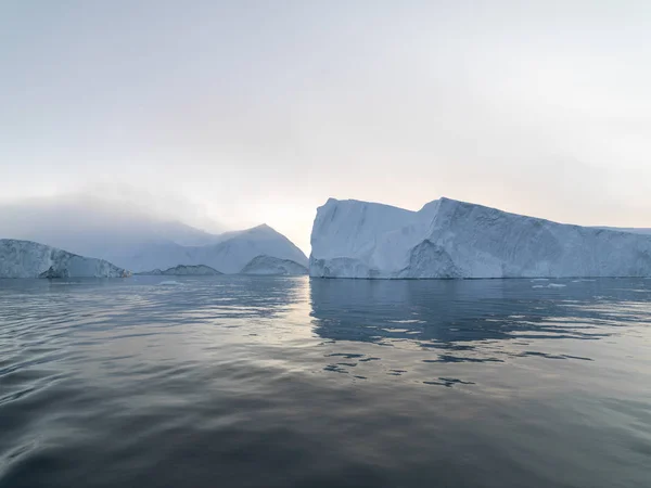 Arctic Icebergs Groenlandia en el mar Ártico. Usted puede ver fácilmente que el iceberg está sobre la superficie del agua, y debajo de la superficie del agua. A veces increíble que el 90% de un iceberg esté bajo el agua — Foto de Stock