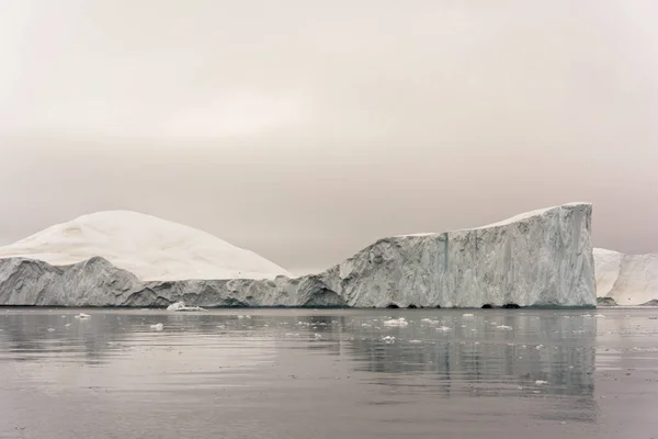 Arctic Icebergs Greenland in the arctic sea. You can easily see that iceberg is over the water surface, and below the water surface. Sometimes unbelievable that 90% of an iceberg is under water — Stock Photo, Image