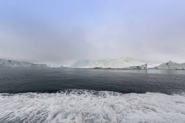 Arktiske isfjell Grønland i Arktis. Man ser lett at isfjellet er over vannflaten og under vannflaten. Noen ganger utrolig at 90% av et isfjell er under vann – stockfoto