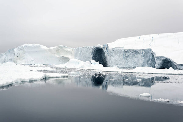 Ледяной покров Гренландии в арктическом море. Можно легко увидеть, что айсберг находится над поверхностью воды и под поверхностью воды. Иногда невероятно, что 90% айсберга находится под водой.
