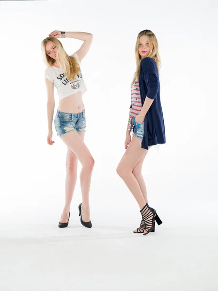 Two blonde girls in shorts jean at studio — Stock Photo, Image