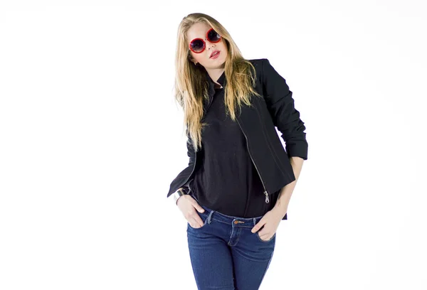 Молода блондинка позує в синій джинсовій і чорній куртці в студії — стокове фото
