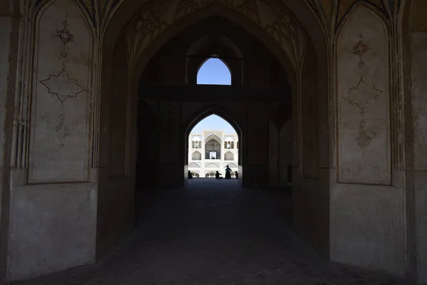 Emberek sziluettje, alatt a boltív a mecset Kashan, Irán. Szeptember-2016 — Stock Fotó