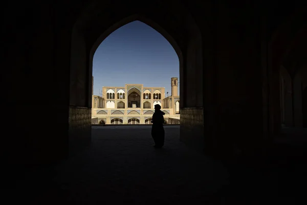 Silhouette populaire sous l'arche de la mosquée de Kashan, en Iran. septembre 2016 — Photo