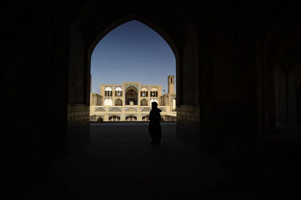 De silhouet van de mensen onder de boog van de moskee in Kashan, Iran. September 2016 — Stockfoto