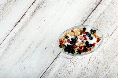 Yoğurtlu cam kase içinde meyve salatası