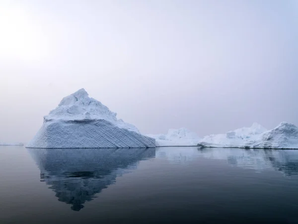 Big icebergs on arctic ocean in a foggy day in Greenland