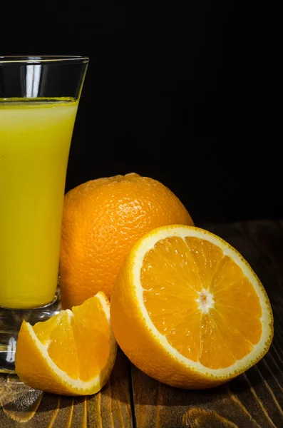 Glass of juice, orange on a black background — Stock Photo, Image