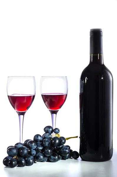 Пляшка червоного вина, келихи для вина та виноград — стокове фото