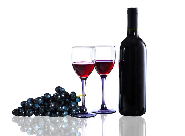 Botella de vino tinto, copas de vino y uvas sobre un fondo blanco — Foto de Stock