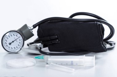 Tek kullanımlık şırınga ve beyaz bir arka plan üzerinde siyah bir stetoskop