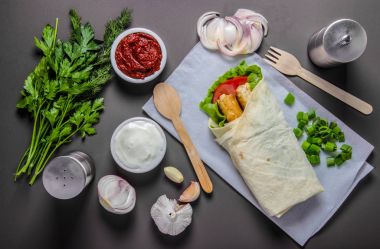 ahşap bir masa üzerinde sebzeli pide