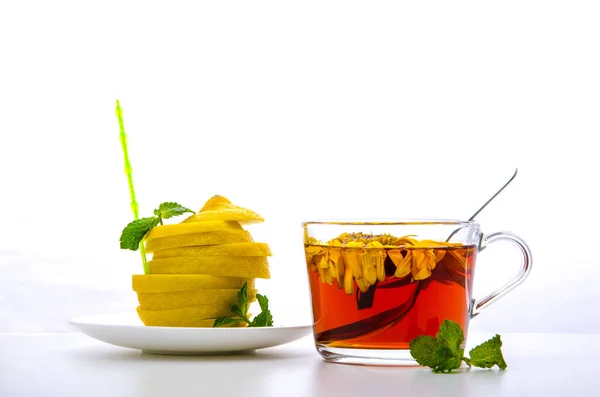 çiçek çay, nane, beyaz bir backgrou üzerinde kesilmiş limon ile cam fincan