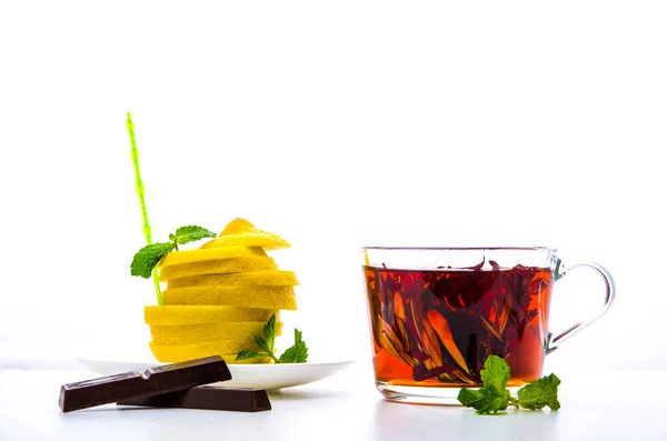 Šálek s čajem, máta, čokolády a nasekaný citrón na bílém pozadí — Stock fotografie