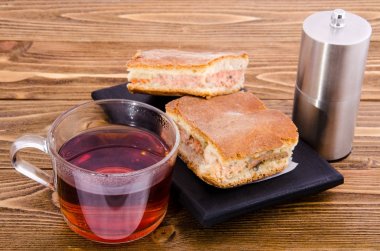 pasta balık ve bir fincan çay tuz shaker ve siyah bir zemin üzerine biber ile