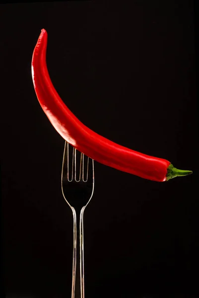 Tenedor con gran pimiento rojo y perejil sobre un fondo negro —  Fotos de Stock