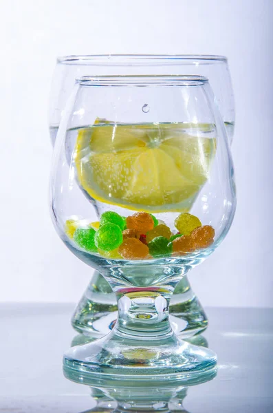 limon ve karamel monpantis beyaz bir arka plan üzerinde iki bardak su