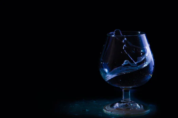 Бризки води в склянці на чорному фоні — стокове фото
