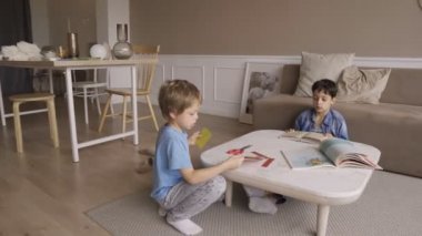 5 yıldır konsantre olmuş çocuk, kağıdı tutkuyla makasla kesiyor. Dil sarkıyor. Yoğunlaştırılmış 5 yıllık çocuk kağıdı tutkuyla makasla kesiyor. Yapıştı.